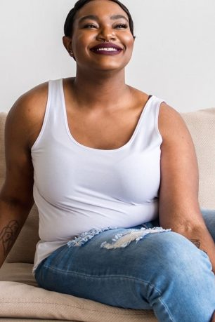 A woman wearing a white tank from Wear Franc, a minimalist clothing brand.